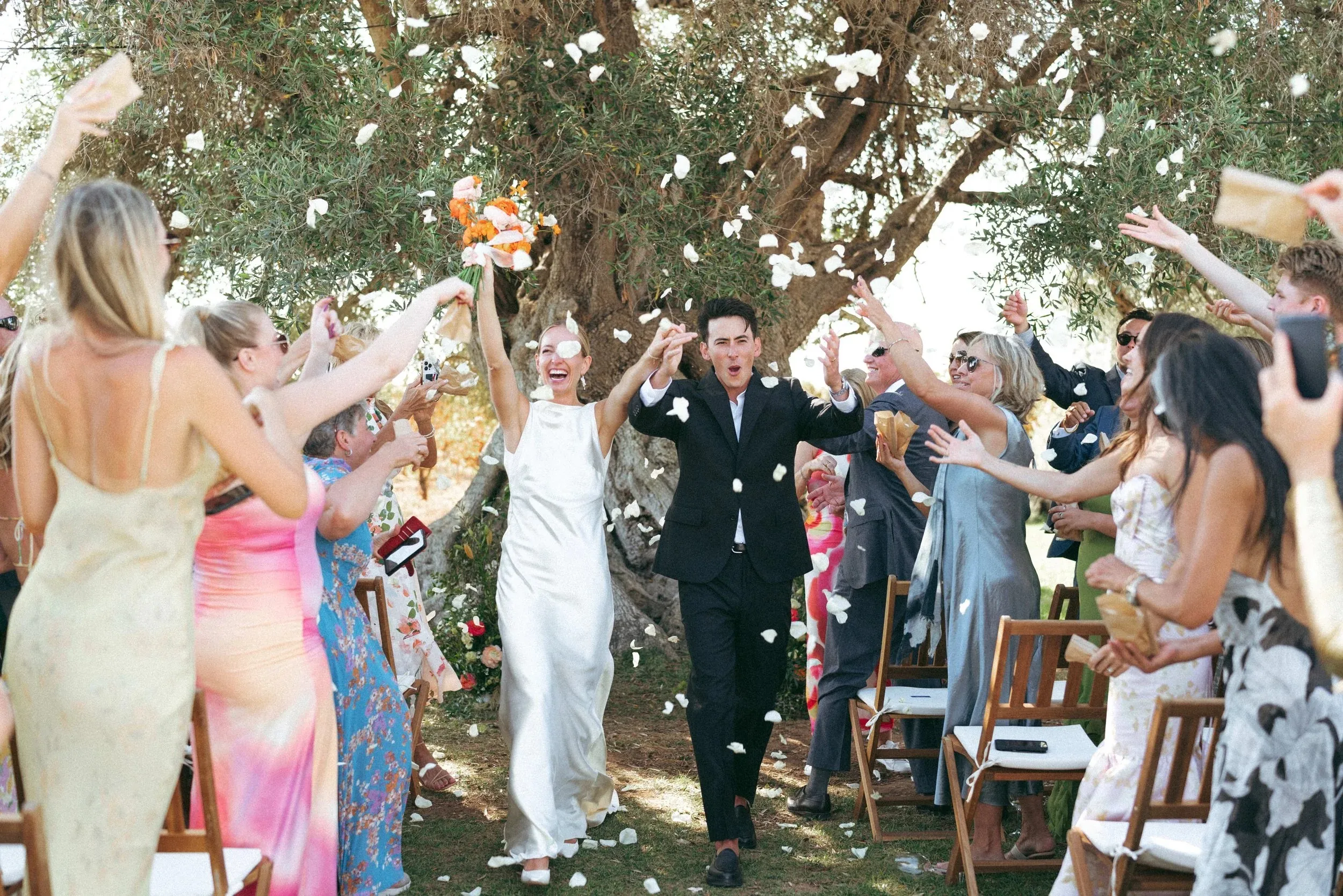 Guests throwing petals as the couple leave the ceremony