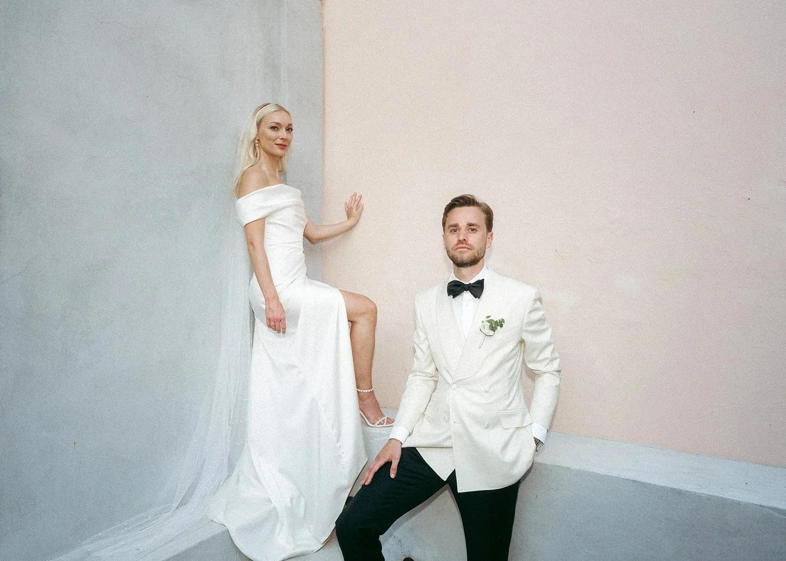 Alexandra and Lukas against a pale pink wall