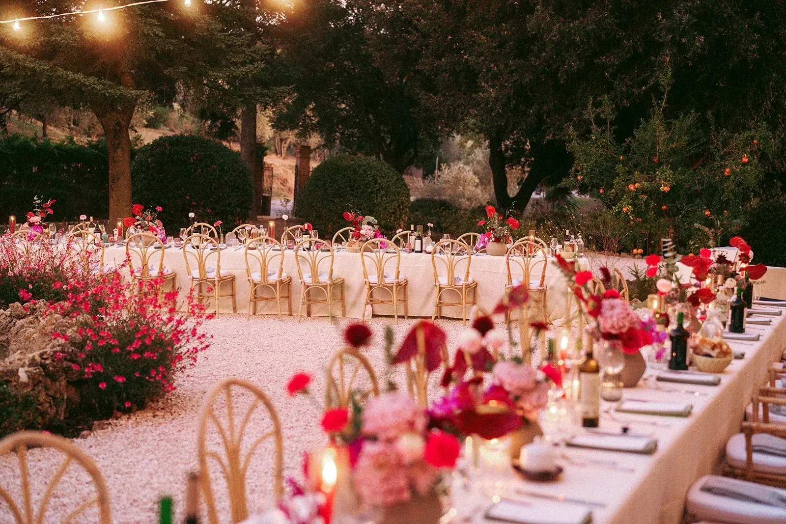 Dinner tables set among flowers at dusk