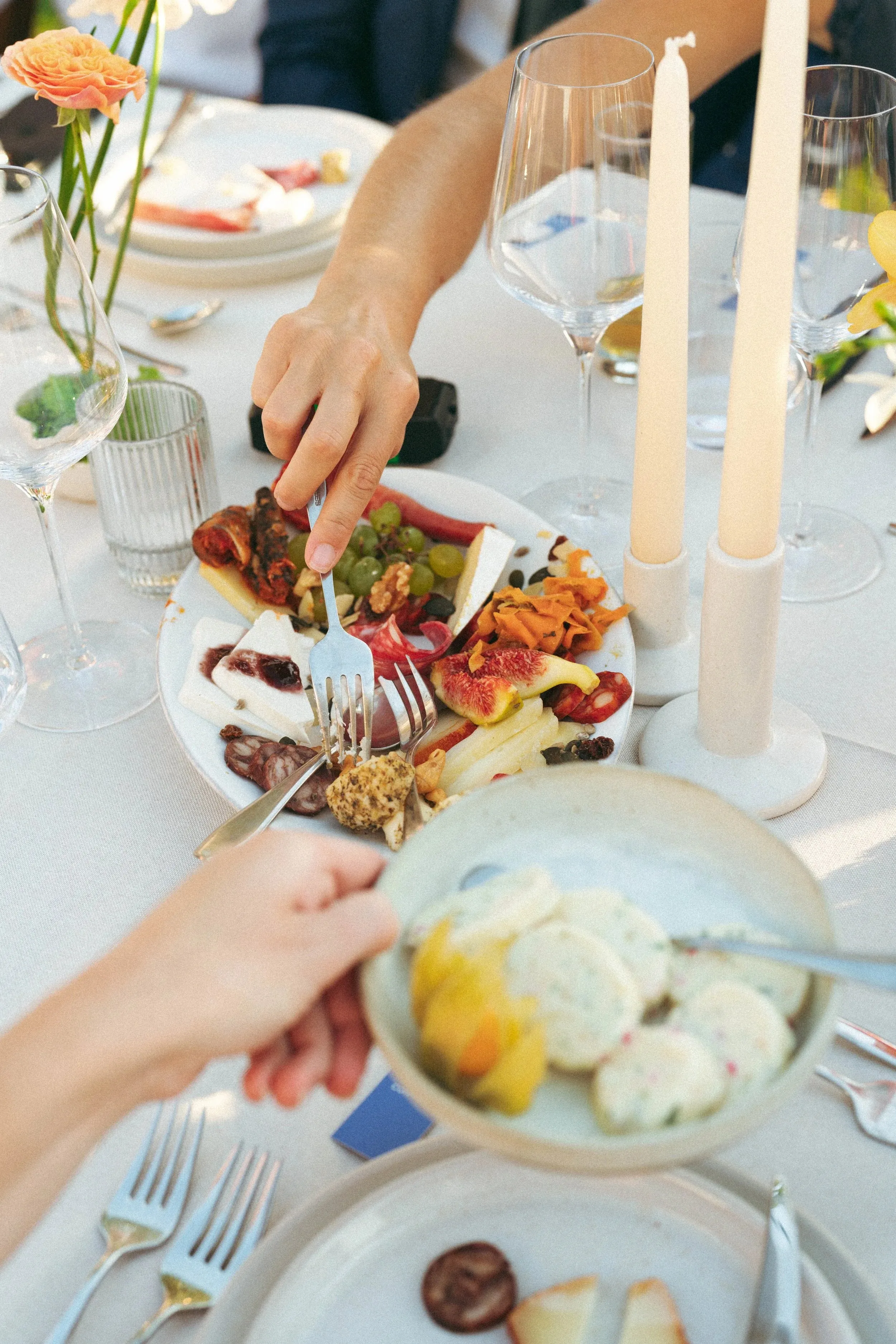 Hands reaching across the table, sharing food